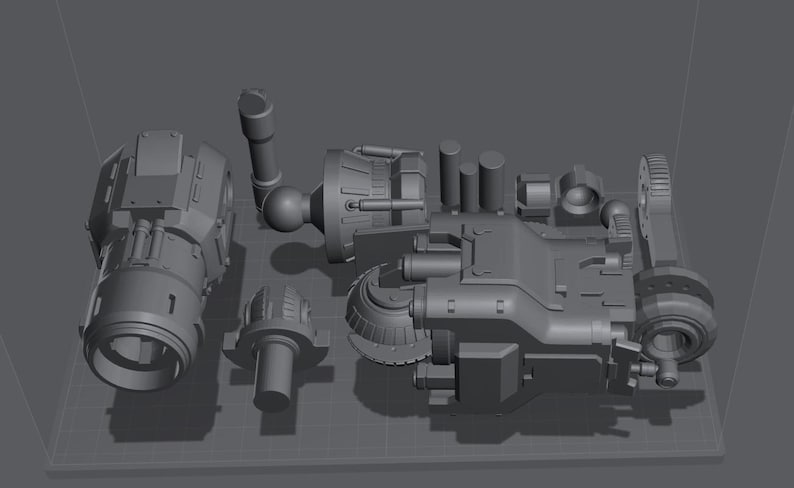May include: A collection of gray, mechanical components, possibly for a larger machine or model. The parts include cylindrical, rounded, and rectangular shapes, suggesting a complex assembly. The pieces are arranged on a grid-like surface.
