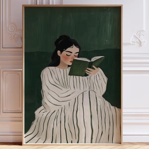 Könnte beinhalten: Ein Kunstdruck mit einer Person, die ein Buch liest. Die Illustration zeigt eine Person in einem weißen Kleid mit vertikalen schwarzen Streifen, die vor einem dunkelgrünen Hintergrund sitzt. Das Kunstwerk ist in einem goldfarbenen Rahmen gerahmt.