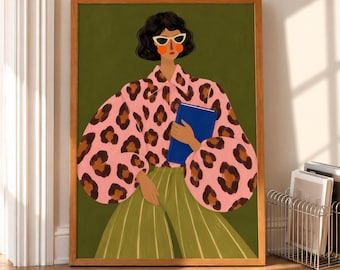 May include: A framed art print featuring an illustration of a person with dark hair wearing white cat-eye sunglasses, a pink leopard print blouse with voluminous sleeves, and a green pleated skirt, while holding a solid blue book.