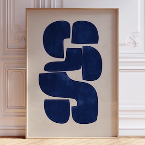 Puede incluir: Un cuadro enmarcado con un diseño abstracto en azul marino sobre un fondo beige. La obra de arte presenta formas redondeadas y conectadas. El marco es de madera clara, y la impresión se muestra contra una pared blanca.