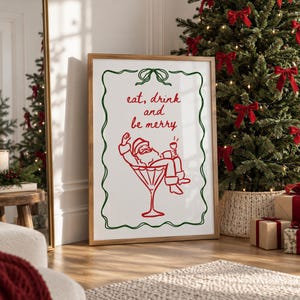 May include: A rectangular framed wall art print featuring a white background with a green decorative border. The red text reads "eat, drink and be merry" above a red line drawing of Santa Claus relaxing inside a large martini glass.
