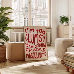May include: A white poster with a red graphic that says "I'm too clumsy to be around fragile masculinity".