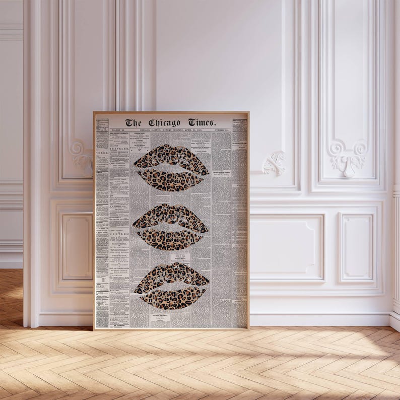 May include: A framed print displaying three leopard-print lip designs. The background is a vintage newspaper, with the headline "The Chicago Times" visible. The frame is light wood, creating a stylish contrast. The artwork combines retro and contemporary styles.