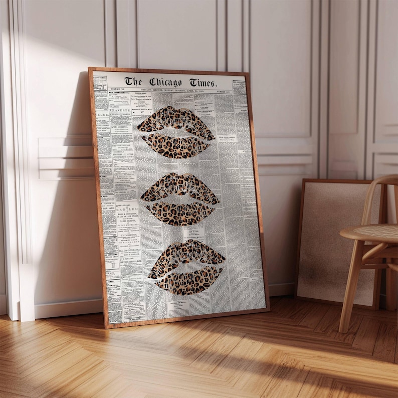 May include: A framed print displaying three leopard print lips set against a backdrop of a vintage newspaper. The title "The Chicago Times" is visible at the top. The frame is a warm brown, enhancing the artwork's aesthetic.
