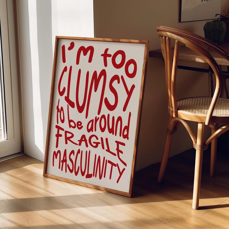 May include: A framed print with a white background and red text that reads "I'm too clumsy to be around fragile masculinity."