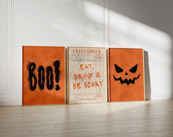 May include: Three framed Halloween-themed prints. The left print says "BOO!" in black, the center print is a guest check with "EAT, DRINK & BE SCARY" text, and the right print features a jack-o'-lantern face.