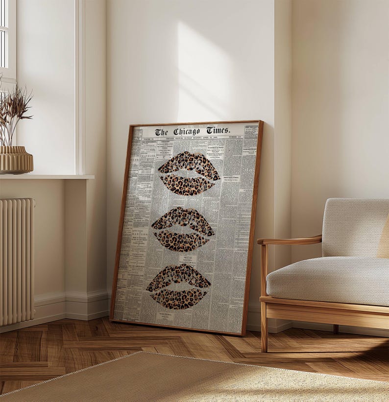 May include: A framed art print displaying three leopard print lips against a backdrop of a vintage newspaper. The print, titled "The Chicago Times", is presented in a wooden frame. The artwork is leaning against a wall.