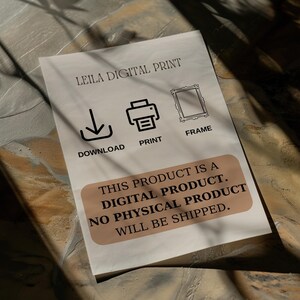 May include: A white card with the text "LEILA DIGITAL PRINT" in black. The card has three icons: a download arrow, a printer, and a picture frame. The text "THIS PRODUCT IS A DIGITAL PRODUCT. NO PHYSICAL PRODUCT WILL BE SHIPPED." is printed in black on a brown rectangle.