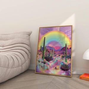 May include: A framed print of a desert landscape with a rainbow arching over the scene. The desert is a vibrant pink and purple with green cacti and plants.