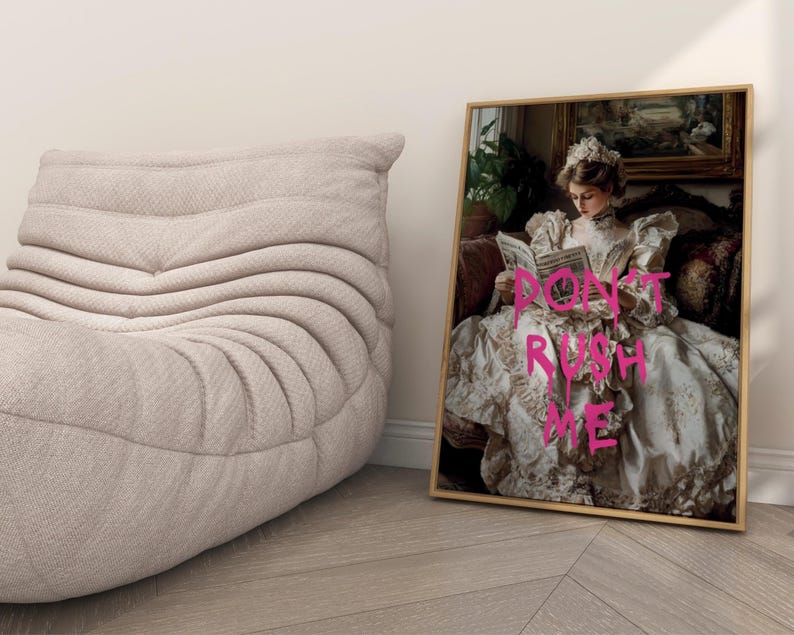 May include: A framed print of a woman in a white dress with the text "DON'T RUSH ME" written in pink on her dress.
