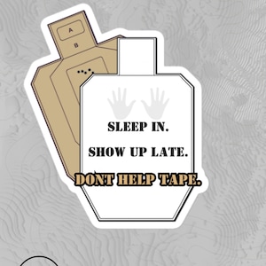 May include: White sticker with a target silhouette and the text "SLEEP IN. SHOW UP LATE. DONT HELP TAPE."  Two handprints are above the text. The sticker is on a gray background.