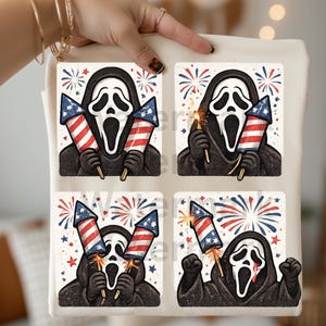 K&ouml;nnte beinhalten: Eine cremefarbene Tragetasche mit vier quadratischen Grafiken der Ghostface-Maske aus den Scream-Filmen. Jede Grafik zeigt die Maske mit Feuerwerk in Rot, Wei&szlig; und Blau, zur Feier des 4. Juli.