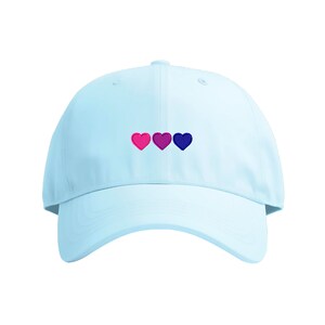 May include: A light blue baseball cap with three embroidered hearts in pink, purple, and blue.