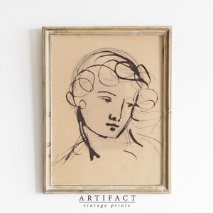 Puede incluir: Un dibujo en blanco y negro de un rostro con cabello rizado, enmarcado en un marco de madera clara. La obra de arte se titula "ARTIFACT vintage prints".