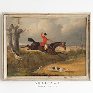 Puede incluir: Una pintura al óleo vintage que representa a un hombre a caballo cabalgando por un campo con tres perros corriendo a su lado. El hombre lleva un abrigo rojo y un sombrero negro. El caballo es marrón y los perros son blancos y marrones.