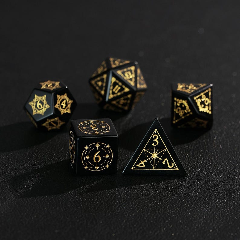 May include: A set of five black polyhedral dice with gold-colored markings. The dice include a d4, d6, d8, d10, and d20, commonly used in tabletop role-playing games. The dice are arranged on a dark surface.