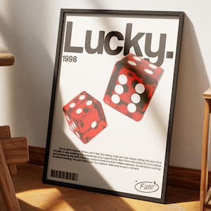 May include: A framed poster with the word "Lucky" in large black letters, and the year "1998" below. Two red dice with white dots are featured. The poster has a black frame and includes text at the bottom.