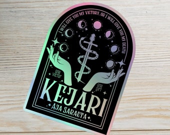 Op de afbeelding: Een zwarte en iriserende sticker met een halve maan en ster ontwerp. De sticker toont een zwaard en twee handen met de tekst "Ik zal je mijn overwinning geven, of ik zal je mijn dood geven." en "KEJARI +AJA SARAETA+".