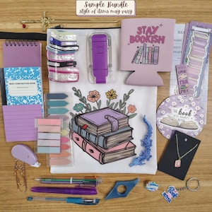 May include: A collection of stationery and book-themed items including a white pouch with a stack of books illustration, a purple 'STAY BOOKISH' sleeve, a mini composition notebook, sticky notes, pens, a necklace, a keychain, and bookmarks.