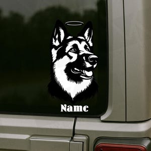May include: A black and white decal of a German Shepherd dog with a halo above its head. The dog's head is in profile, with its mouth open and tongue visible. The word "Name" is printed in white below the dog.