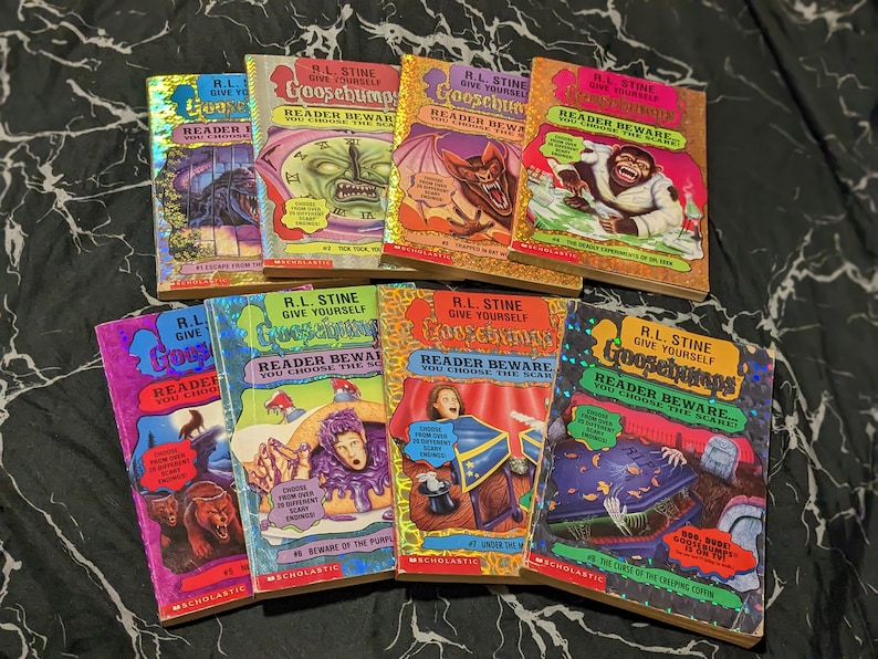 May include: A collection of eight R.L. Stine Give Yourself Goosebumps books with holographic covers. Titles include Escape from the Carnival of Horrors, Tick Tock, You're Dead, Trapped in Bat Wing Hall, The Deadly Experiments of Dr. Eek, and others.