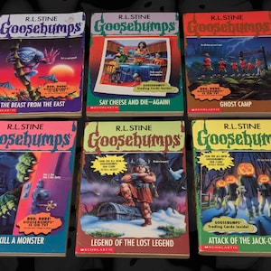 以下が含まれることがあります： R.L. Stineによる6冊のヴィンテージ「Goosebumps」本のコレクション。表紙には、モンスターや不気味なシーンのカラフルなイラストが描かれています。「The Beast from the East」や「Attack of the Jack-O'-Lantern」などのタイトルが含まれています。