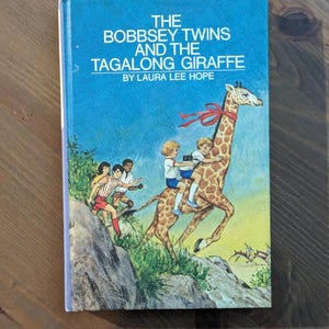 BOBBSEY TWINS and the Tagalong GIRAFFE par Laura Lee Hope - édition 1973 à couverture rigide illustrée de collection, livre mystère pour enfants