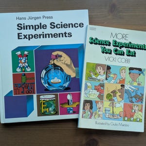 May include: Two vintage science experiment books. One book is titled "Simple Science Experiments" by Hans Jürgen Press. The other book is titled "More Science Experiments You Can Eat" by Vicki Cobb.