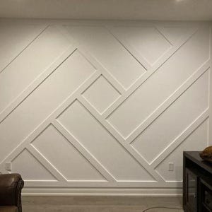 May include: A white wall with a geometric pattern of squares and rectangles. The wall is painted white and the trim is also white.