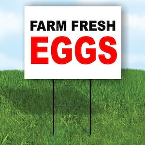 May include: A white sign with the words "FARM FRESH EGGS" in black and red lettering, displayed on a metal stake in a grassy field. The sky is blue with a few clouds.