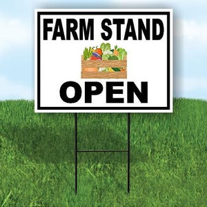 May include: White sign with black text that reads "Farm Stand Open". A cartoon image of a crate of fresh produce is in the center of the sign.