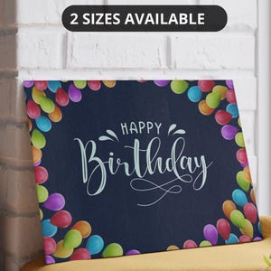 May include: A rectangular birthday-themed canvas print with a dark blue background. The words "HAPPY Birthday" are written in white script. Colorful balloons frame the edges. The text "2 SIZES AVAILABLE" is in a black oval at the top.