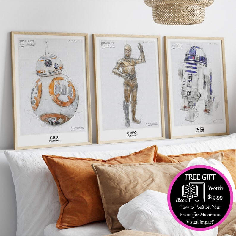 Może przedstawiać: Trzy oprawione ilustracje postaci z Gwiezdnych Wojen. Ilustracje są w stylu szkicu oł&oacute;wkiem. Postacie to BB-8, C-3PO i R2-D2. Ramy są z jasnego drewna, a tło jest białe.