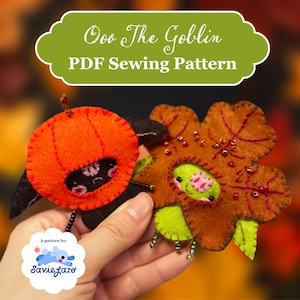 May include: Two felt goblin plushies, one orange pumpkin-shaped and one brown leaf-shaped with green accents and bead details. Text at the top reads Ooo The Goblin PDF Sewing Pattern, and a small white logo at the bottom reads A pattern by: SavieLaze.