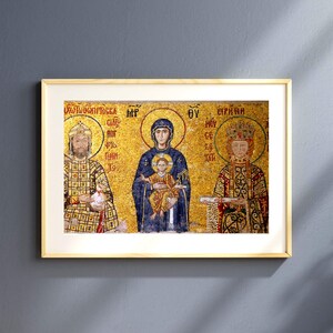 Pode incluir: Obra de arte emoldurada com um mosaico bizantino. O mosaico retrata três figuras com auréolas sobre um fundo dourado. A figura central segura uma criança. A obra de arte está em uma moldura dourada.