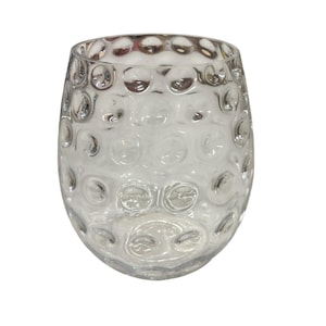 May include: Clear glass stemless wine glass with a textured, bubble-like pattern. The glass has a rounded shape and is designed for holding beverages. The glass is transparent, allowing the contents to be visible.