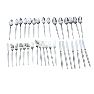 May include: A collection of stainless steel flatware, including spoons, forks, knives, and butter knives. The handles have a textured design. The arrangement suggests a formal dining setting.