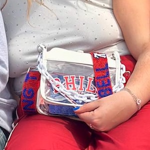 Bolso bandolera transparente PHILA aprobado para estadios con correa de cuentas en rojo y azul con el mensaje “Ring the Bell”
