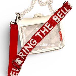 Cartera transparente tipo bandolera aprobada por el estadio con correa de cuentas con la leyenda "RING THE BELL"