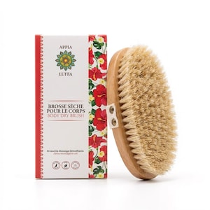 Puede incluir: Un cepillo corporal de madera con cerdas naturales, junto a una caja con el texto "APPIA LUFFA BODY DRY BRUSH". La caja tiene un borde rojo y un estampado floral con flores rojas y hojas verdes. El cepillo tiene forma ovalada.