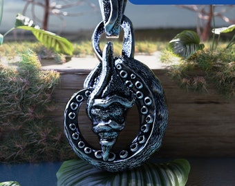 Peut inclure: Un pendentif en argent avec un design détaillé d'un coquillage à la surface texturée. Le pendentif est entouré d'un cercle de petites perles.