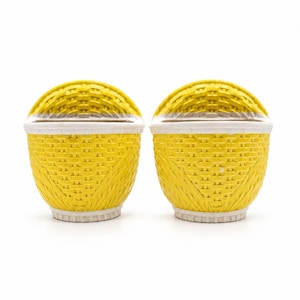 May include: A pair of bright yellow ceramic salt and pepper shakers featuring a moulded basket weave texture. Each shaker has a rounded top, a white rim, and a white base, designed with a consistent pattern of woven strips.