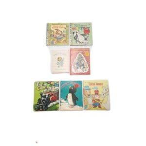 May include: A collection of vintage children's books with colorful illustrations. Titles include "Dog Goes to Nursery School," "Panda Bear's Picnic," and "Train Coming." The books feature images of animals, a train, and holiday scenes.
