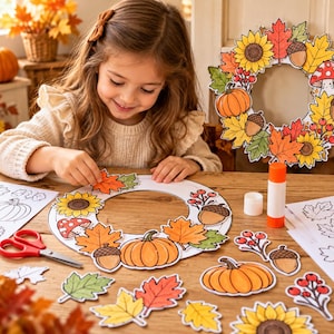 Puede incluir: Un proyecto de manualidades con una base de corona de papel circular, recortes coloridos de calabazas, girasoles, bellotas, setas y hojas de otoño, un pegamento en barra y tijeras de mango rojo sobre una superficie de madera.