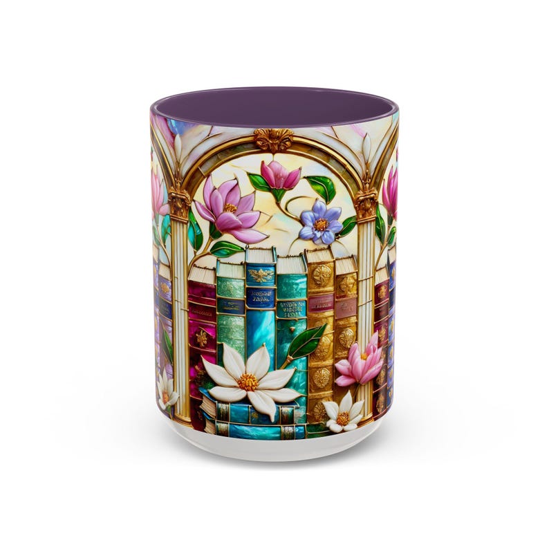May include: A white ceramic coffee mug with a stained-glass design featuring a stack of books, flowers, and an arched window frame. The mug has a purple interior and a white base. The flowers are pink, white, and blue.