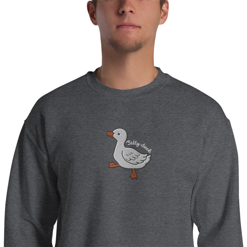 May include: A dark gray sweatshirt with an embroidered white duck with orange feet and the text "Silly duck" in white.
