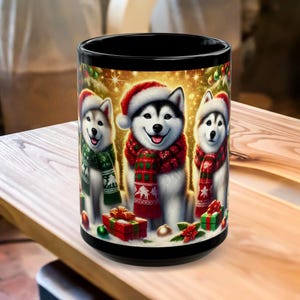 May include: Black ceramic mug featuring three smiling husky dogs wearing Santa hats and festive scarves. The dogs are surrounded by Christmas decorations and gift boxes, creating a holiday theme.