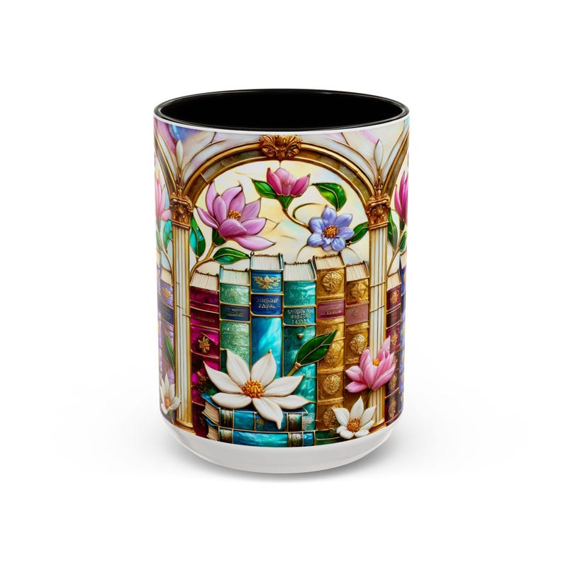 May include: White ceramic mug with a black interior, featuring a colorful stained-glass design. The design includes a row of books, pink and purple flowers, and gold accents. The mug has a glossy finish and a white base.