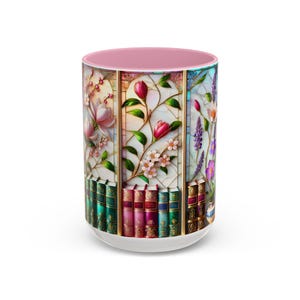 May include: A ceramic coffee mug with a white base and a pink interior. The exterior features a stained-glass design with floral panels and a row of books at the bottom. The flowers include pink magnolias, red tulips, and purple lavender.