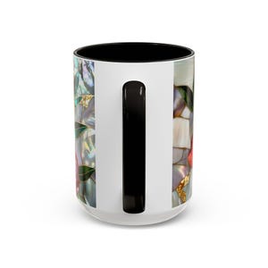 Pu&ograve; includere: Tazza in ceramica bianca con interno e manico neri. La tazza presenta un colorato motivo floreale con accenti dorati e un effetto vetrata. Il design include sfumature di rosa, verde e bianco.